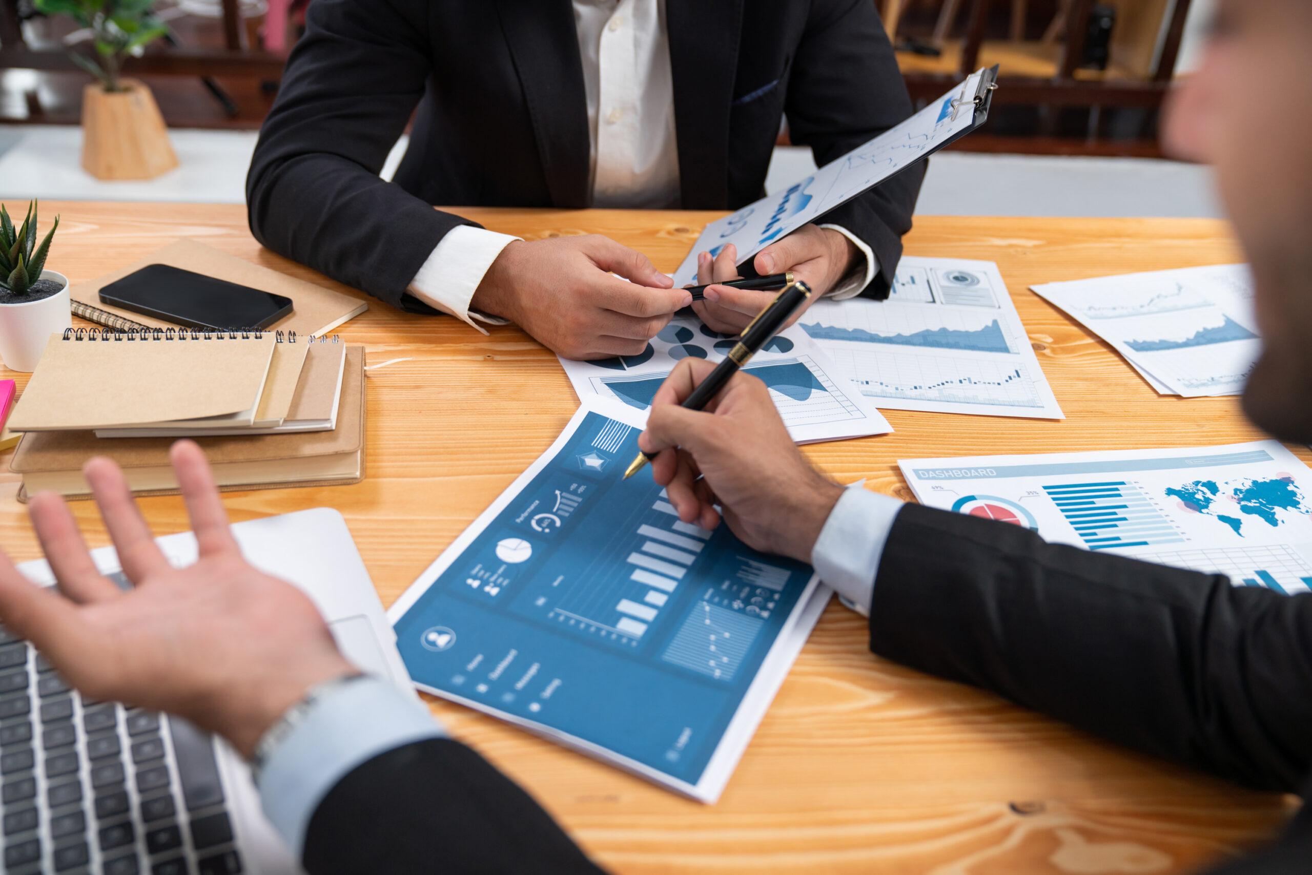 two-people-sitting-table-one-them-is-holding-chart-that-says-financial